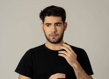 Genç düşünceli Latin adam endişeli görünümlü ve bir sorun için bir çözüm düşünme üzgün yakın. İnsan yüz ifadeleri ve duygular insanlar. Stüdyo çekim nötr arka planda izole.