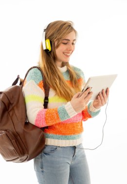 Bir video öğretici online lanet izlerken veya müzik dinlerken tablet kullanarak kulaklıklar mutlu genç ergen öğrenci kadın portre. İzole beyaz arka plan. Teknoloji ve öğrenci yaşam tarzı.