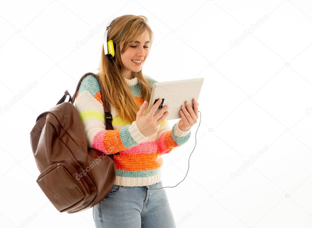 Portrait of happy young teenager student woman in headphones using tablet watching a video tutorial online curse or listening to music. Isolated white background. In technology and student lifestyle.