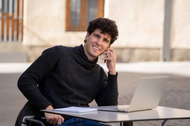 Genç adam sohbet ve mesajlaşma konuşmak için akıllı cep telefonu uygulaması kullanarak ve bir kentsel Avrupa şehir kahve terasında selfie alarak. Online dating mobil uygulama Internet bağlantıları ve teknoloji kullanımı.