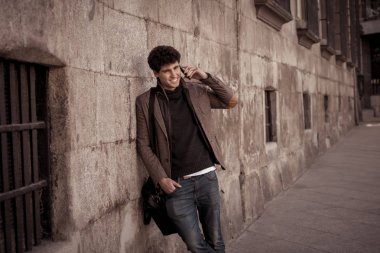 Söz ve akıllı telefon üzerinde sosyal medya arkadaşıyla tatil günlerinde Avrupa'da sohbet mutlu onun yirmili genç çekici adam. İletişim, teknoloji internet ve yaşam tarzı konsepti.