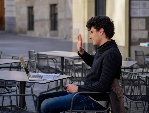 Yakışıklı genç adam bir Avrupa şehir kahve dükkanında teras dışında dizüstü bilgisayar üzerinde çalışıyor. Öğrenci Duygu mutlu ve memnun. Avrupa'da online eğitim ve teknoloji konsepti nde seyahat.