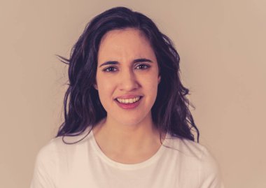 Öfkeli yüz ile stres genç çekici sinirli Latin kadın yakın. Kızgın ve öfkeli jestler yaparak hayal kırıklığına bakıyordu. Nötr arka planda. İnsan yüz ifadeleri ve duygular.