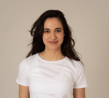 Mutlu yüz güzel gülümseme ve uzun siyah saçlı çekici esmer genç latin kadının yakın portresi. Nötr arka planda izole edilmiş. İnsanlar, pozitif insan yüz ifadesi ve duygu.