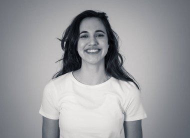 Mutlu yüz güzel gülümseme ve uzun siyah saçlı çekici esmer genç latin kadının yakın portresi. Nötr arka planda izole edilmiş. İnsanlar, pozitif insan yüz ifadesi ve duygu.