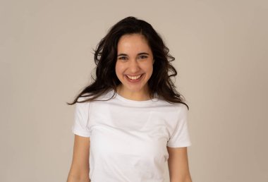 Mutlu yüz güzel gülümseme ve uzun siyah saçlı çekici esmer genç latin kadının yakın portresi. Nötr arka planda izole edilmiş. İnsanlar, pozitif insan yüz ifadesi ve duygu.