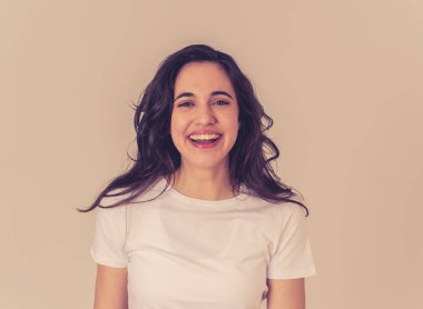 Mutlu yüz güzel gülümseme ve uzun siyah saçlı çekici esmer genç latin kadının yakın portresi. Nötr arka planda izole edilmiş. İnsanlar, pozitif insan yüz ifadesi ve duygu.
