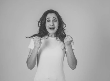 Genç çekici latin kadın kazanan başarı kutluyor ya da silah ile kutlama jestleri yapma şanslı ve neşeli dans hissi. İnsanlar ifadeler ve duygular nötr arka plan izole.