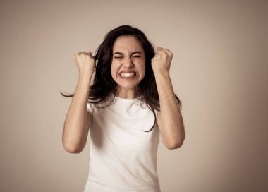 Genç çekici latin kadın kazanan başarı kutluyor ya da silah ile kutlama jestleri yapma şanslı ve neşeli dans hissi. İnsanlar ifadeler ve duygular nötr arka plan izole.