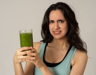 Sağlıklı yeşil meyve suyu tutan çekici diyet kız diyet detoks pürüzsüz içecek sıkıcı sevmediğim jestleri gösteren. Sağlıklı gıda, Beslenme fitness ve kilo kaybı kavramı gri arka plan izole.