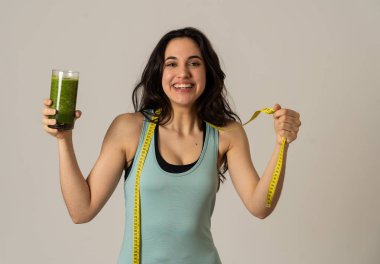 Fitness kadın gevşek kilo diyet planı ile mutlu gülümseyen; egzersiz ve yeşil sebze smoothie sağlıklı içecek. Güzellik vücut bakımı, Sağlık Fitness Diyet Beslenme ve sağlıklı Yaşam tarzı kavramı.
