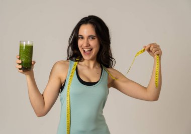 Fitness kadın gevşek kilo diyet planı ile mutlu gülümseyen; egzersiz ve yeşil sebze smoothie sağlıklı içecek. Güzellik vücut bakımı, Sağlık Fitness Diyet Beslenme ve sağlıklı Yaşam tarzı kavramı.