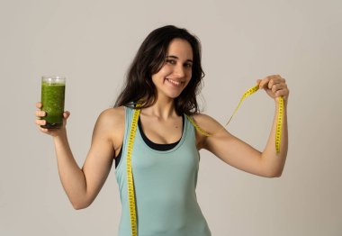 Fitness kadın gevşek kilo diyet planı ile mutlu gülümseyen; egzersiz ve yeşil sebze smoothie sağlıklı içecek. Güzellik vücut bakımı, Sağlık Fitness Diyet Beslenme ve sağlıklı Yaşam tarzı kavramı.