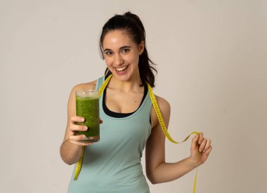 Fitness kadın gevşek kilo diyet planı ile mutlu gülümseyen; egzersiz ve yeşil sebze smoothie sağlıklı içecek. Güzellik vücut bakımı, Sağlık Fitness Diyet Beslenme ve sağlıklı Yaşam tarzı kavramı.