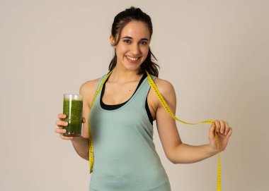 Fitness kadın gevşek kilo diyet planı ile mutlu gülümseyen; egzersiz ve yeşil sebze smoothie sağlıklı içecek. Güzellik vücut bakımı, Sağlık Fitness Diyet Beslenme ve sağlıklı Yaşam tarzı kavramı.