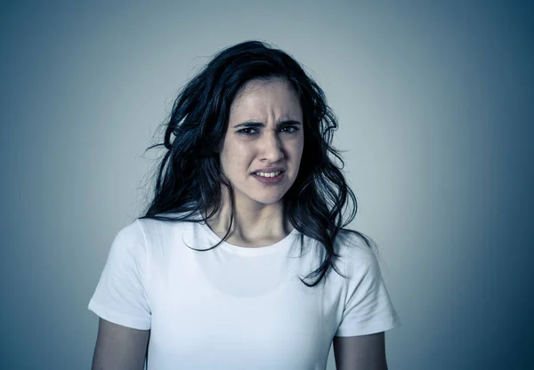 Young latin woman feeling disgust looking at something unpleasant making fear, anxiety gestures trying to cover herself in shock. Portrait with copy space. People and Human expression and emotion.