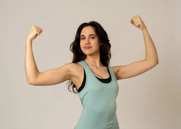Cheerful latin strong woman in sportswear looking healthy and sexy. Portrait of fit young woman wearing gym top posing happy and funny in stretching and workout poses In Fitness and Body care concept.