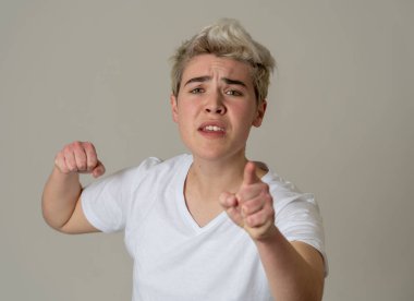 Kızgın yüzü ile genç çekici transseksüel genç adam Portresi. Kızgın ve öfkeli görünüyorsun. Yüz ifadeleri ve duygular. Nötr arka planda yalıtılmış.