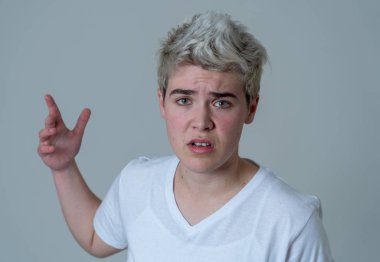 Kızgın yüzü ile genç çekici transseksüel genç adam Portresi. Kızgın ve öfkeli görünüyorsun. Yüz ifadeleri ve duygular. Nötr arka planda yalıtılmış.