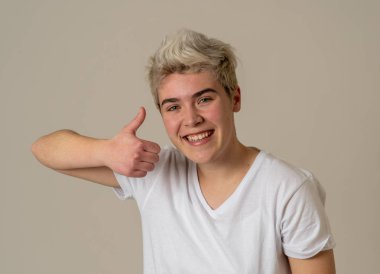 İyi görünümlü genç adamın portresi, neşeli, mutlu ve memnun duygu başparmak kadar gösterir. Genç mutlu öğrenci erkek beyaz arka planda izole neşeli onay jest kadar başparmak yapma.