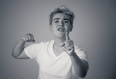 Kızgın yüzü ile genç çekici transseksüel genç adam Portresi. Kızgın ve öfkeli görünüyorsun. Yüz ifadeleri ve duygular. Nötr arka planda yalıtılmış.