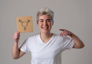 İyi görünümlü mutlu ve gururlu trans genç bir karton plaka üzerine çizilmiş transseksüel sembolü tutan. Cinsiyet kimliği ve çeşitliliğinin kavramsal imgesi. İnsan hakları ve eşitlik kampanyası.