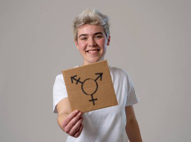 Good looking happy and proud trans teenager holding the symbol of the transgender drawn on a cardboard plate. Conceptual image of gender identity and diversity. Human rights and equality campaign. clipart