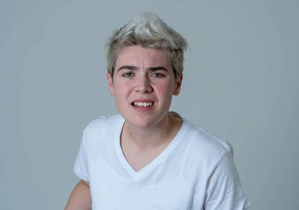 Portrait of young attractive transgender teenager man with angry face. Looking mad and furious. Facial expressions and emotions. Isolated on neutral background.