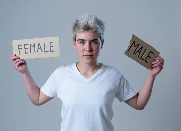 Handsome transgender teenager tearing the word Female into MALE in Gender identity, equality and human rights. Breaking silence about own gender identity transgender Pride and freedom concept.