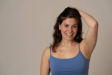 Kıvırcık saçlı, çekici yüzü ve rahat yaz üstü poz güzel bir gülümseme ile genç güzel beyaz kadın Portresi. In People Beauty insan ifadeleri ve pazarlama dostu görüntü.