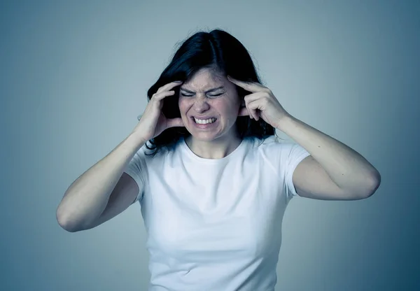 Close up portrait of young sad woman, serious and concerned, looking worried in pain with headache suffering from migraine. Isolated on neutral background. In facial expressions and healthcare.