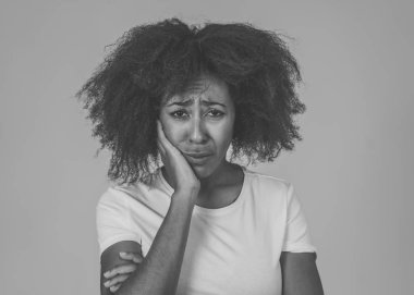 Üzgün ve bitkin yüzü ile acı içinde Afrikalı Amerikalı kadının Portresi endişeli görünümlü, endişeli ve düşünceli insan duyguları Ruh sağlığı ve Depresyon. Nötr arka planda yalıtılmış.