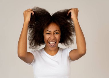 Mutlu yüz güzel gülümseme ve afro saçlı çekici Afrikalı Amerikalı kadının yakın portresi. Nötr arka planda izole edilmiş. İnsanlarda, olumlu insan yüz ifadeleri ve duygular.