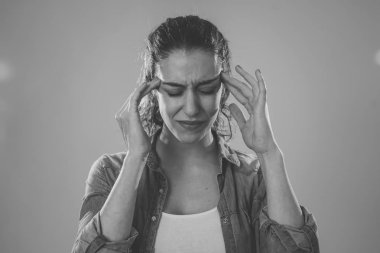 Büyük acı migren muzdarip endişeli ve düşünceli görünümlü genç bir kadının yakın portresi. Nötr arka planda izole edilmiş. Yüz ifadeleri ve duygular ve sağlık kavramı.