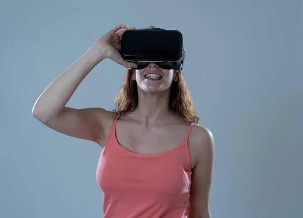 Curious woman happy and excited to use virtual reality goggles feeling excited about simulation, exploring virtual life making happy gestures. In New technology Virtual Augmented Reality concept.