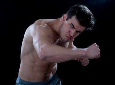 Güç ve motivasyon. Güçlü fitness adam mücadele boks egzersiz spor salonu eğitim siyah arka plan üzerinde izole güçlü bir yumruk atma. Spor ile ilgili reklam için görüntü dostu.