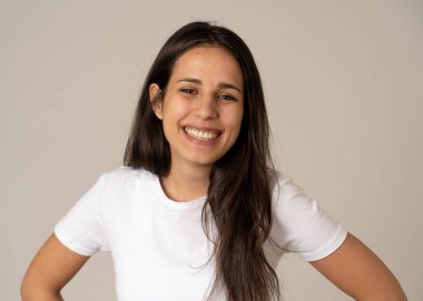 Mutlu yüz güzel gülümseme ve uzun siyah saçlı çekici esmer genç latin kadının yakın portresi. Nötr arka planda izole edilmiş. İnsanlarda, olumlu insan yüz ifadeleri ve duygular.