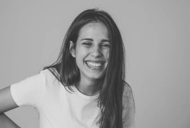 Mutlu yüz güzel gülümseme ve uzun siyah saçlı çekici esmer genç latin kadının yakın portresi. Nötr arka planda izole edilmiş. İnsanlarda, olumlu insan yüz ifadeleri ve duygular.