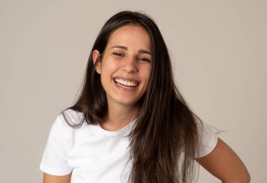 Mutlu yüz güzel gülümseme ve uzun siyah saçlı çekici esmer genç latin kadının yakın portresi. Nötr arka planda izole edilmiş. İnsanlarda, olumlu insan yüz ifadeleri ve duygular.