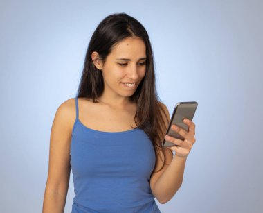 Genç latin kadın mutlu sosyal medya uygulaması video veya blog şok bakıyor. Sürpriz genç kız takipçileri çok sahip ve online medya da seviyor. Bin yıllık nesil ve teknoloji kullanımı.