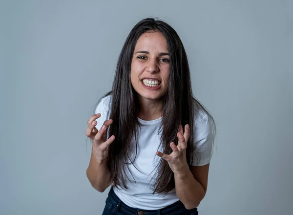 Close up of young attractive frustrated latin woman in stress with furious face. Looking mad and disappointed making angry gestures. In neutral background. In human facial expressions and emotions.