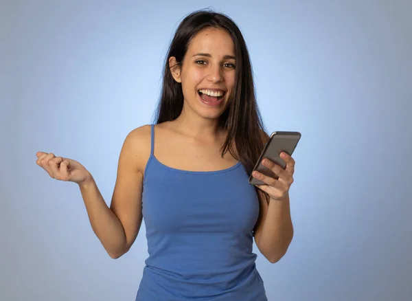 ソーシャルメディアアプリの出会い系サイトで幸せにショックを受けたモバイル上の若いラテン女性 多くのフォロワーを持つティーンエイジャーの女の子は 技術を使用してミレニアル世代でオンラインビデオブログに好き — ストック写真