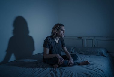 Harap bin yıllık adam üzgün duygu acı ve umutsuz acı Depresyon ağlıyor. Geceleri umutsuzluk içinde yatakta tek başına oturan zorbalık veya istismar depresif genç kurbanı. Genç Ruh sağlığı.