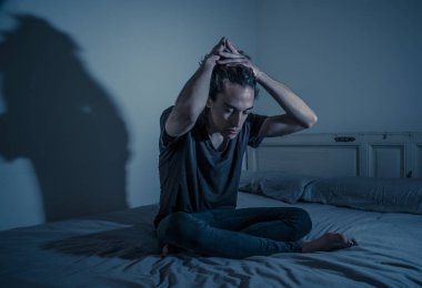 Harap bin yıllık adam üzgün duygu acı ve umutsuz acı Depresyon ağlıyor. Geceleri umutsuzluk içinde yatakta tek başına oturan zorbalık veya istismar depresif genç kurbanı. Genç Ruh sağlığı.