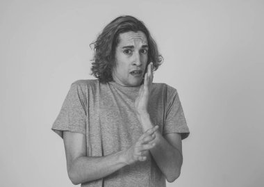 Genç adam korkmuş ve korku ve anksiyete korkmuş jestler yaparak şok hissi. Dehşete düşmüş çaresiz bir genç kendini saldırganlıktan korumaya çalışıyor. Halk ifadeleri ve gençlik şiddeti.