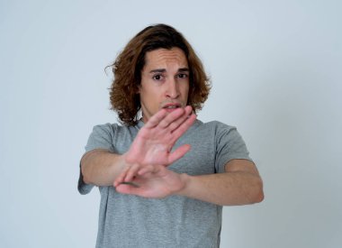 Genç adam korkmuş ve korku ve anksiyete korkmuş jestler yaparak şok hissi. Dehşete düşmüş çaresiz bir genç kendini saldırganlıktan korumaya çalışıyor. Halk ifadeleri ve gençlik şiddeti.