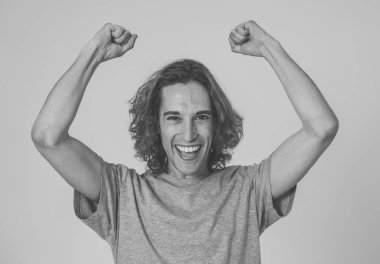 Piyangoyu kazanmayı ya da büyük başarılar elde eden çok heyecanlı genç adamın portresi. Uzun saçlı ve şaşırmış ve mutlu jestleri olan genç. İnsanlar yüz İfade ve İnsan Duygular.