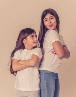 Bir tartışma olan etkileşim kardeş portresi. Ablası dilini dışarı yapışmasını ve kızgın üzgün küçük kız kardeşi ne kadar komik yüzler yapıyor birbirleriyle konuşmuyor. Kardeşler kötü ilişki.