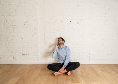 Emlakçı ya da stüdyoda akıllı telefonda ev avcısı adam. Genç hipster sahibi cep telefonuyla yeni boş dairesinde daire kiralamak için konuşuyor. Gayrimenkul yatırım satın alma ve kiralama iş.