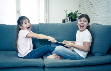 Genç ve yaşlı kızlar internet üzerinde oynarken üzerinde tartışma dizüstü bilgisayar için mücadele. Kardeşler ve teknoloji bağımlılığı kavramı arasındaki ilişkide bilgisayarı paylaşmayan kız kardeşlerin yaşam tarzı portresi.